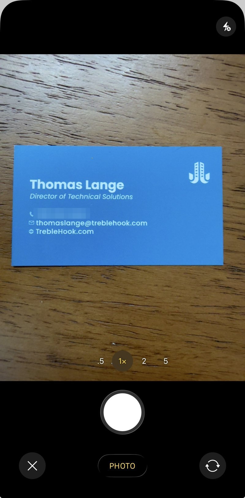 The Salesforce mobile camera framing a business card on a table, ready to scan.